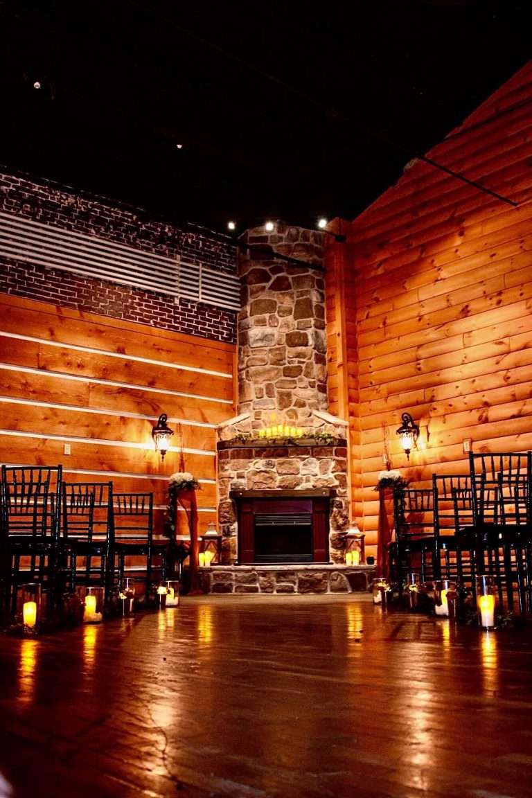 A dining room with red lighting and a fireplace in the center